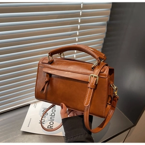 Dettaglio della borsa a tracolla vintage in pelle PU marrone con finiture dorate e nodo