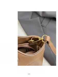 Detail of premium gold-toned metal hardware and zipper on the brown leather tote bag