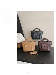 Detailed view of mini matte leather handbags in black, tan and brown with shoulder straps
