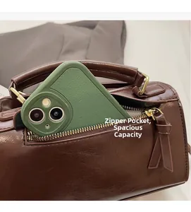 Dettaglio di borsa in pelle lucida marrone scuro con tasca a zip e finiture dorate
