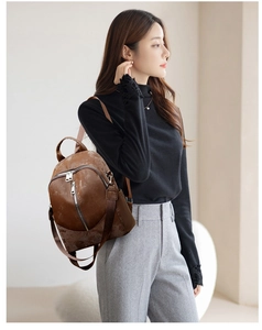 Seitenansicht eines Vintage-Damenrucksacks aus dunkelbraunem Kunstleder getragen von einem Model