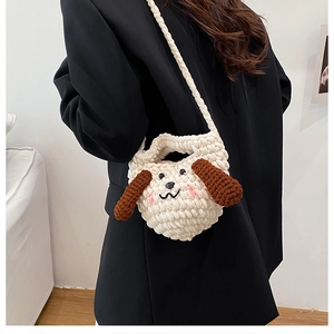 Détails du tricot d'un sac à bandoulière fait main en forme de chien porté par le mannequin