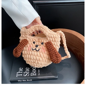 Détail d'un sac chiot au crochet fait main avec oreilles brunes et visage brodé