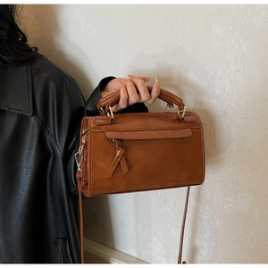 Dettaglio della borsa in pelle PU caramello con nodo decorativo e finiture dorate