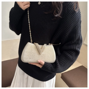 Detail of evening clutch with sparkling crystals and a detachable gold chain strap
