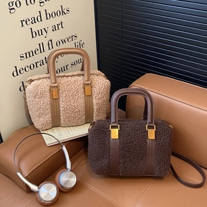 Detail of plush faux fur handbags in beige and coffee with gold metal buckles and leather straps