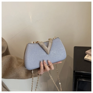 Detailed view of the sparkling light blue evening bag with crystal V-shape metal clasp