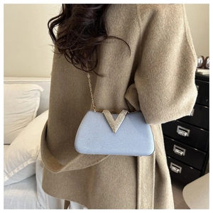 Detail of light blue evening clutch with pearl texture and crystal-inlaid V-shaped buckle