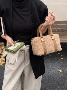 Detail of plush winter faux fur handbag with leather handle in an autumn setting