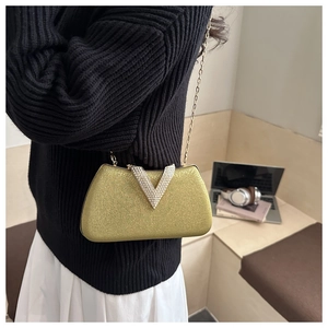 Detail of gold glitter evening clutch with V-shaped rhinestone buckle and metal chain strap