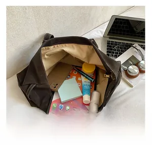 Spacious interior of dark brown leather tote bag showing items for daily office commute