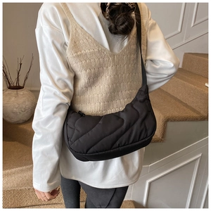 Detailed view of the large black quilted shoulder bag with soft nylon texture and crescent shape