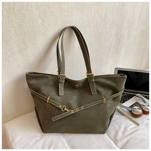 Detail of olive green tote bag with gold hardware, strap buckle and laptop accessories