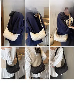 Detailed side view of cloud quilted crescent bag with adjustable wide strap on model