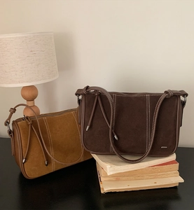 Detail view of suede tote bags in ginger and dark coffee with white contrast stitching