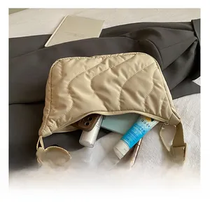 Detail view of large beige quilted crossbody bag showing spacious interior capacity