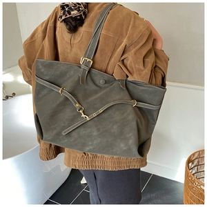 Detailed view of the large dark green suede tote bag showing its actual size on a model
