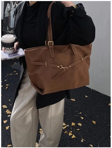 Brown vintage faux leather tote bag detail with decorative strap and magnetic closure