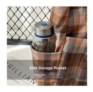 Detail of canvas tote side pocket holding a glass water bottle on plaid fabric