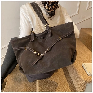 Close-up of matte brown tote bag with premium metal buckles and soft suede texture