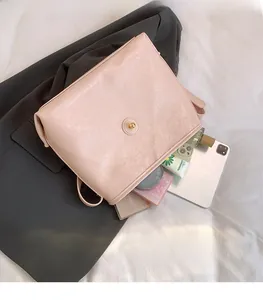 Interior storage view of pink PU leather crossbody bag showing daily essentials and metal lock
