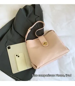 Detail of nude pink bucket bag showing size comparison with iPad and phone