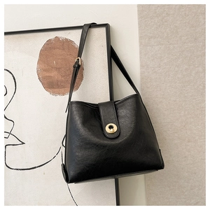 Detail of black matte tote bag with elegant golden metal buckle and wrinkled texture