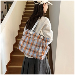 Detail of checkered canvas tote bag showing side pocket and spacious design