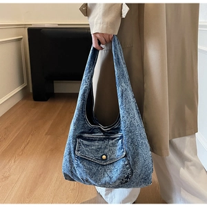 Detail der blauen Denim Hobo-Tasche mit funktionaler Klappentasche und Metallschnalle