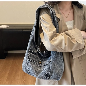 Detailansicht der großen schwarzen Vintage-Denim-Tote-Bag mit Vordertasche am Modell