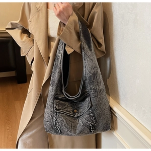 Details der grauen Jeans-Hobo-Tasche mit Vordertasche und Vintage-Metallknopf-Element