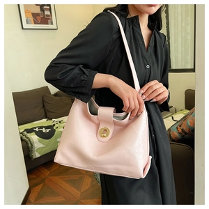 Detail of light pink shoulder bag with golden round turn-lock buckle and smooth leather