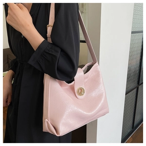 Detail of pink glossy PU leather tote bag featuring a premium gold circular metal clasp