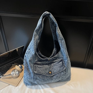 Detail der Jeans-Tragetasche mit Acid-Wash-Effekt, Vordertasche und Messing-Metallknopf
