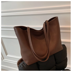 Close-up of deep brown tote bag showing premium lychee pattern leather texture