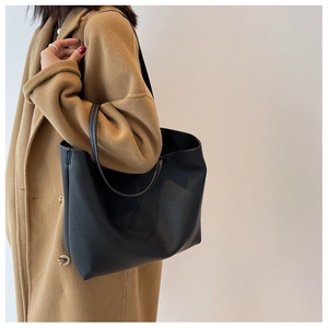 Detailed view of black large capacity tote bag featuring premium lychee grain leather