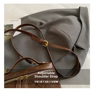 Détail de la bandoulière réglable en cuir avec boucle dorée sur un sac matelassé
