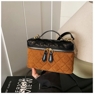 Détails des surpiqûres en losange et texture mixte sur un sac bandoulière bicolore chic