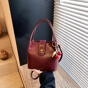 Sac seau vintage en cuir bordeaux avec fermoir doré et pendentif cerise décoratif
