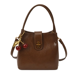 Sac seau vintage marron foncé minimaliste avec boucle dorée et breloque cerise