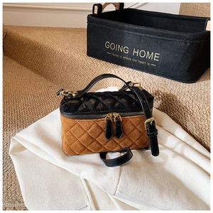 Détail du mini sac bicolore avec texture matelassée et ferrures dorées chic
