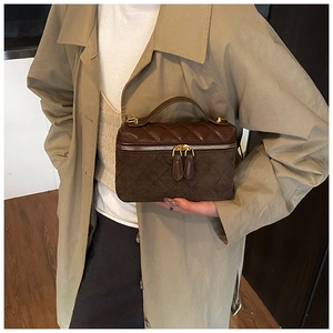 Détail de la trousse de toilette matelassée marron foncé avec anse et zip doré