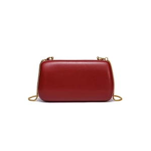 Detail of burgundy evening clutch bag with golden metal clasp and chain strap