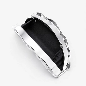 Detail of silver acrylic evening clutch bag showing inner black lining and wave texture