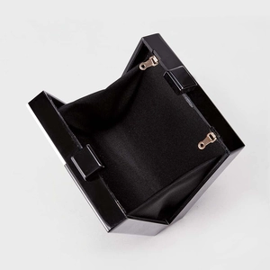 Glossy black acrylic face clutch with golden hardware and fabric lining interior