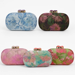 Detail showing five floral brocade evening clutch bags with gold metal clasps in a row