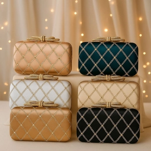 Detailed view of satin evening bags with rhinestone embroidery and bow metal clasp