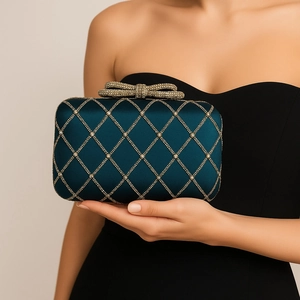 Detail of teal satin evening clutch with gold diamond lattice and rhinestone bow clasp