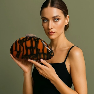 Detail of amber resin clutch bag featuring a rhinestone-encrusted spherical clasp