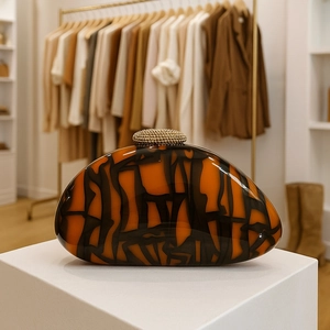 Artistic half-moon acrylic evening clutch with orange and black texture and gold clasp